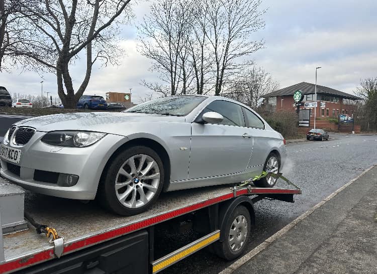 Silver BMW 3 Series coupe loaded for scrap collection