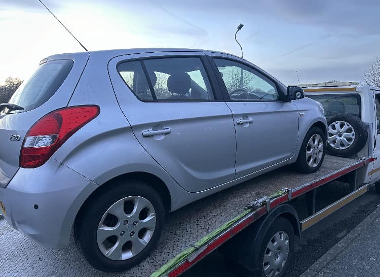 Silver Hyundai i20 on flatbed for scrap collection